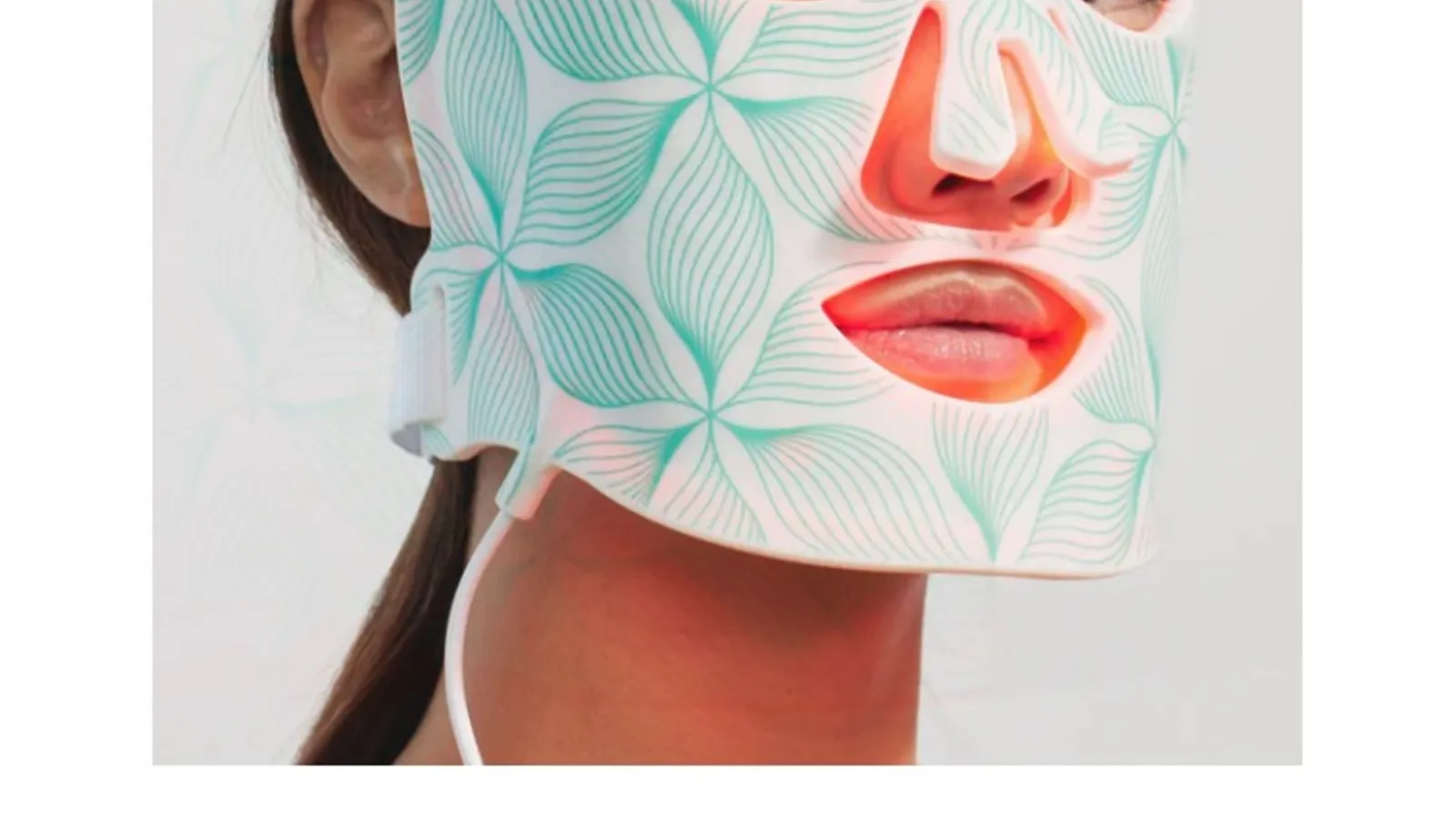 A woman wearing the flexible Omnilux LED light therapy mask