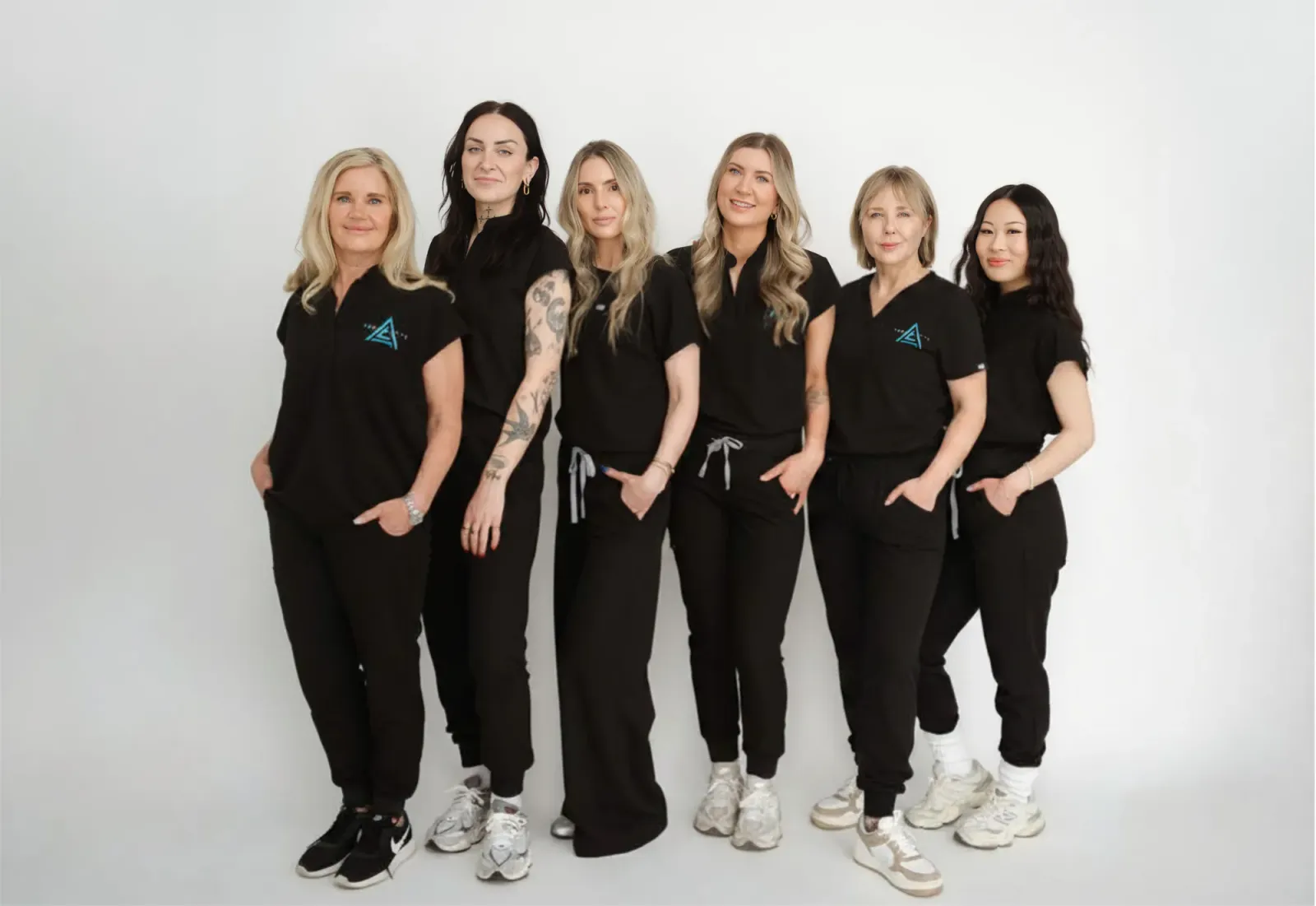 The Ageless Living clinic team in black uniforms standing together in the clinic